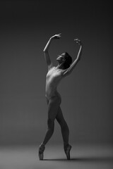 Young beautiful ballerina is posing in studio