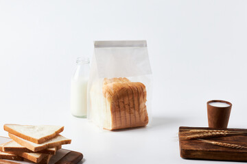 Fresh Bread and Milk on a Clean Kitchen Counter With Wooden Boards and Wheat Stalks