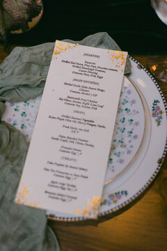 Elegant menu displayed on a vintage plate at a beautifully set dining table for a special event in a cozy interior
