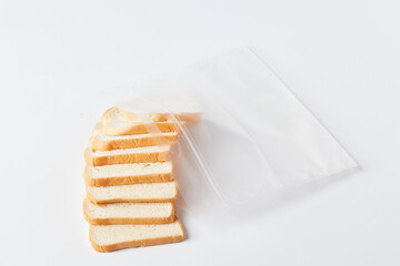 Sliced Bread Being Stored in a Clear Plastic Bag on a White Surface