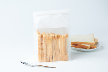 Sliced Bread in Clear Bag With a Plate of Additional Slices on a White Background
