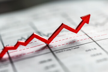 Red arrow is drawn on a graph paper, indicating a positive trend
