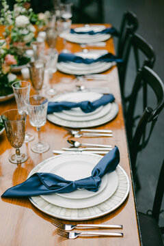 Elegant table setting with fine dining utensils and blue napkins in a beautifully arranged venue