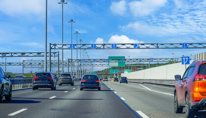 Dense stream of cars on a city road back view on the bypass expressway.