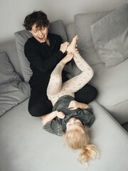Mom tickles her daughter's feet. Checking the child's nerve endings and blood vessels.