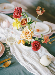 Beautifully arranged floral centerpiece with elegant table setting for a gathering in bright light