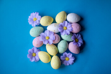 Colorful flowers and Easter eggs on a beautiful background. Easter themed background, frame and poster.