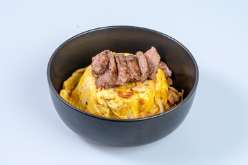 Delicious beef steak served on fluffy omelette with rice, creating satisfying meal. combination of flavors and textures makes it delightful dish for any occasion