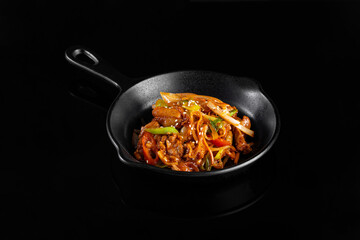 Delicious stir fried vegetables and meat in black skillet, showcasing vibrant colors and textures, perfect for culinary presentation