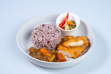 Delicious plate of rice, fried chicken, and vegetables, showcasing colorful and appetizing meal. combination of flavors and textures makes it delightful dining experience