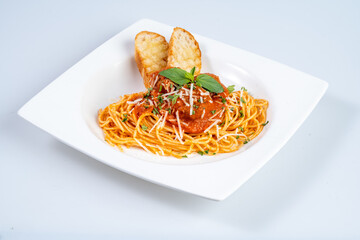 Delicious spaghetti with meatballs, garnished with fresh basil and cheese, served with crispy bread. perfect meal for pasta lovers