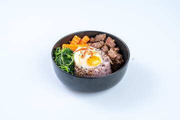 Delicious bowl of rice topped with beef, egg, and vegetables, showcasing vibrant colors and textures, perfect for hearty meal