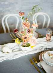 Beautiful floral centerpiece on a dining table set for an elegant occasion with soft lighting and elegant tableware