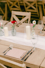 Elegant table setting for an outdoor event with flowers and candles in a serene garden location