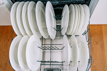 open dishwasher with clean white plates. High quality photo