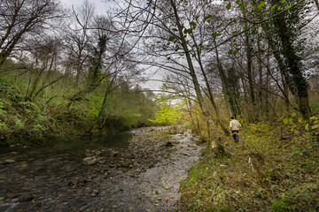 Man is walking along a river bank