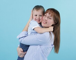 Mother and her cute son on light blue background