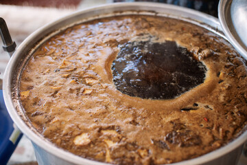 Boiling pork soup in a pot, close-up photo