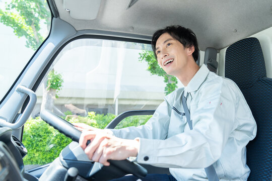 トラックを運転する若い男性