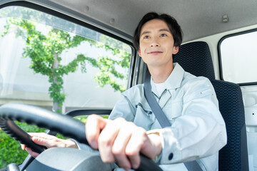 トラックを運転する若い男性