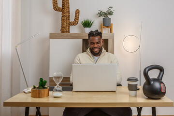 Remote work setup featuring an African American man engaged in productive activities at a stylish...