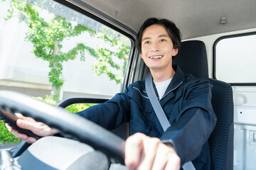 トラックを運転する若い男性