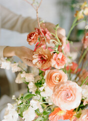 Floral arrangement being created with delicate flowers in a well-lit studio setting during a spring afternoon
