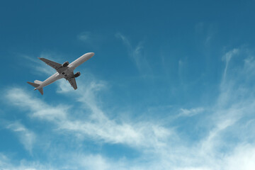 Airplane flying in beautiful blue sky with clouds