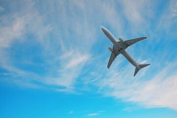 Airplane flying in beautiful blue sky with clouds