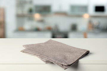 Folded tablecloth on wooden surface in kitchen