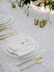 Elegant table setting with floral details and fine china for a spring celebration in a sunny garden