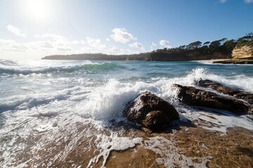 Splashes from waves in the ocean covering rocks on the shore.