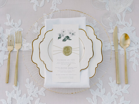 Elegant dining setup with floral menu and gold accents for a special occasion - Powered by Adobe