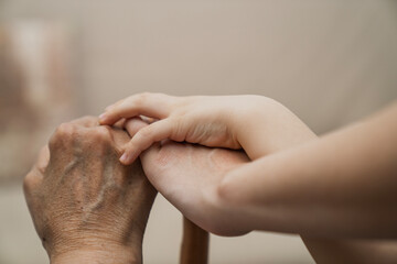 Fototapeta premium Young woman and child holding hand of old woman with cane