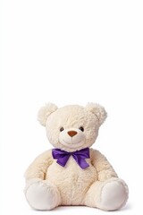 Obraz premium Beige teddy bear wearing purple bow tie sitting on white background
