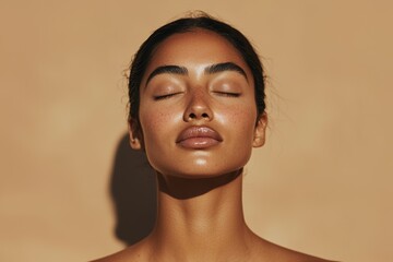 A fresh-faced woman wearing light makeup and glossy lipstick looks straight into the camera
