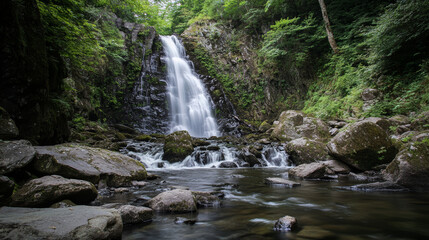 Fototapeta premium Breathtaking waterfall cascading over moss-covered rocks in a dense green forest, with flowing water creating a misty and peaceful natural landscape, ideal for travel, meditation, and relaxation theme