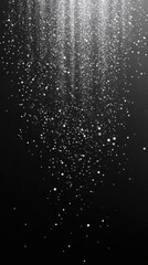 Obraz premium Sparkling silver glitter falling on a dark gradient, silver glitter falling on dark background. Vertical