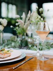 Elegant dining setting with salmon dish and refreshing drink in a lush garden-like atmosphere