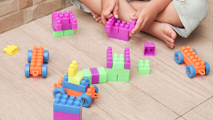 Toddler activity, boy playing with colorful plastick brick or toy block building a thing. Motoric...