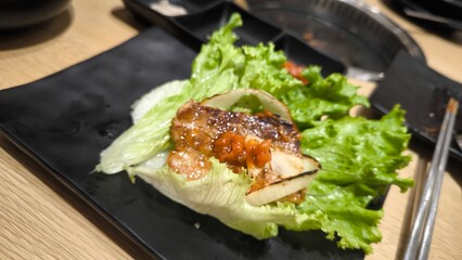 Eating Korean-style grilled meat consisting of meat and vegetables.