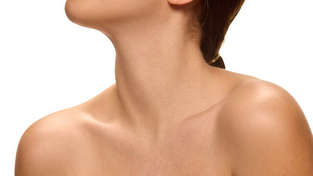 Young woman tilting head back slightly with relaxed posture highlighting neckline against white studio background. Concept of natural beauty, self-care, anti aging procedures, lifting, wellness.