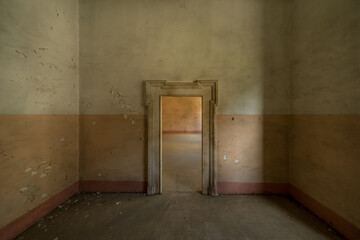 Absolutely symmetrical, empty room with desaturated warm colors and brown tones. A door into...