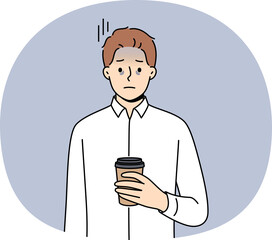 Tired business man suffering from exhaustion and burnout and holding paper cup of coffee in hands. Problems exhaustion among office employee experiencing health difficulties due to constant overtime