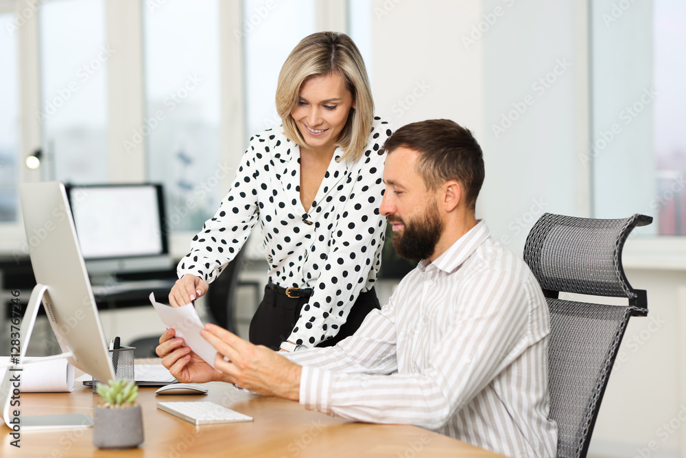Poster technicians making digital engineering drawing on computer at desk in office