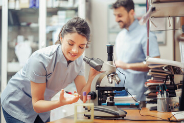 Obraz premium Scientists conducting research in a laboratory using a microscope with samples on the table