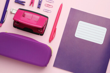 Copybook and other school stationery on pink background, flat lay
