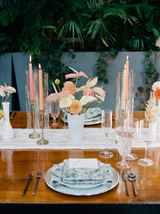 Elegant dining setup featuring floral arrangements and candlelight at a chic venue during a warm evening gathering