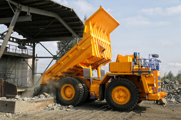 Big yellow mining truck unloads ore. A dump truck unloads ore, coal, granite. No AI tools