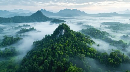 Lush Green Mountain Surrounded by Misty Forest and Majestic Hills Under a Soft Sunrise Sky in a Tropical Paradise